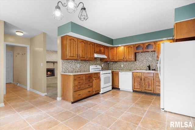 69 Axline Rd, Chatham, IL 62629 - kitchen featuring white appliances, under cabinet range hood, brown cabinetry, light countertops, and light tile patterned floors
