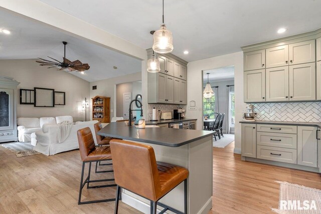 33 Vista Rdg, Petersburg, IL 62675 - kitchen with dark countertops, tasteful backsplash, a kitchen breakfast bar, light wood-style flooring, and a ceiling fan