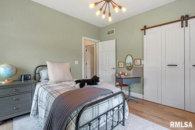33 Vista Rdg, Petersburg, IL 62675 - bedroom with a barn door, a chandelier, light wood-style flooring, a closet, and baseboards
