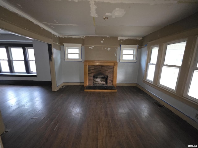 2040 S 5th St, Springfield, IL 62703 - unfurnished living room featuring a fireplace with raised hearth, dark wood-style floors, plenty of natural light, and baseboards