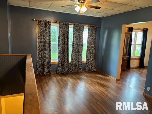 505 E Elm St, Carlinville, IL 62626 - spare room featuring a paneled ceiling, a ceiling fan, healthy amount of natural light, wood finished floors, and baseboards