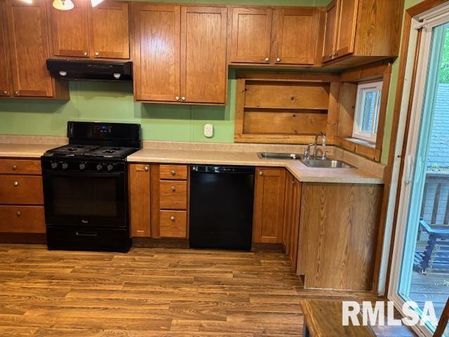 505 E Elm St, Carlinville, IL 62626 - kitchen with black appliances, extractor fan, wood finished floors, light countertops, and a sink