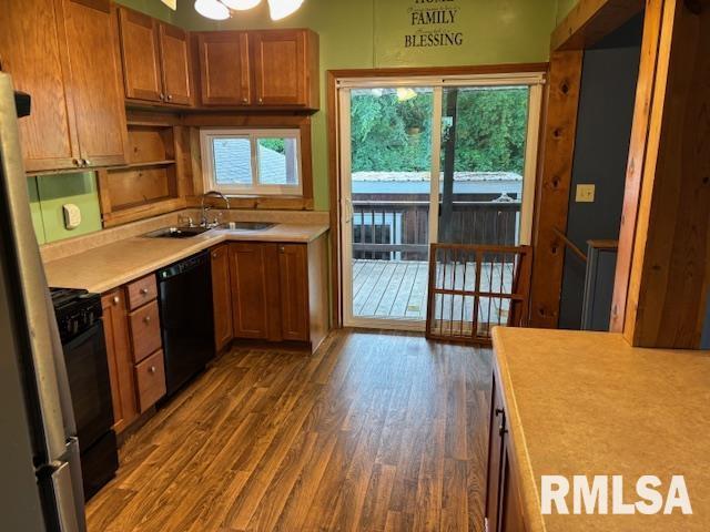 505 E Elm St, Carlinville, IL 62626 - kitchen featuring black dishwasher, a sink, light countertops, dark wood finished floors, and brown cabinets