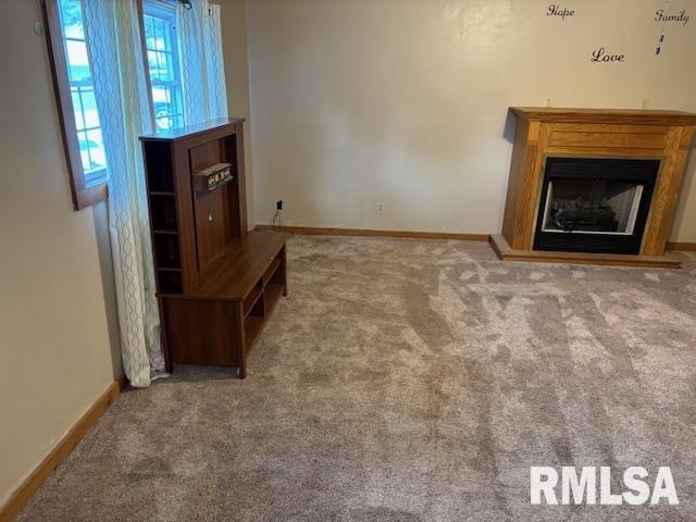 505 E Elm St, Carlinville, IL 62626 - unfurnished living room with carpet floors, baseboards, and a fireplace