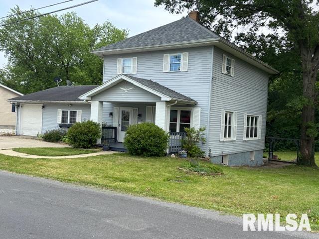 505 E Elm St, Carlinville, IL 62626 - view of front facade featuring covered porch, a chimney, an attached garage, a front lawn, and concrete driveway