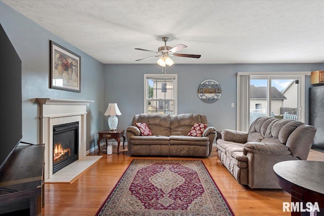 4108 Newtonmore Dr, Springfield, IL 62712 - living room with plenty of natural light, a ceiling fan, a fireplace, light wood-type flooring, and a textured ceiling