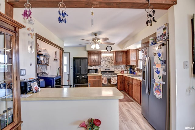 909 E Heights Ave, Taylorville, IL 62568 - kitchen with appliances with stainless steel finishes, tasteful backsplash, light countertops, light wood-style floors, and brown cabinetry