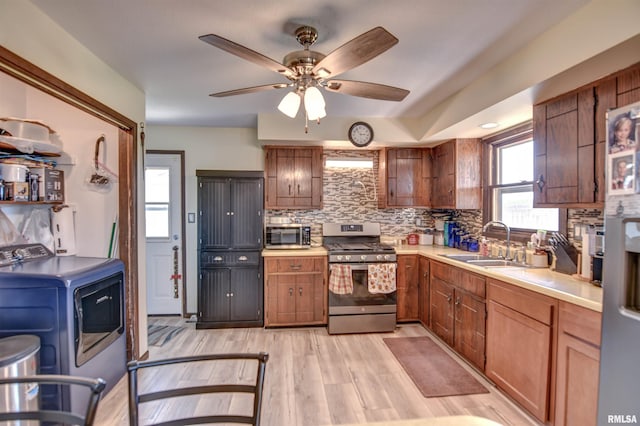 909 E Heights Ave, Taylorville, IL 62568 - kitchen with appliances with stainless steel finishes, washer / dryer, backsplash, light countertops, and ceiling fan