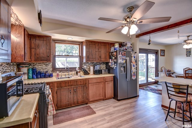 909 E Heights Ave, Taylorville, IL 62568 - kitchen with stainless steel appliances, ceiling fan, light countertops, brown cabinetry, and backsplash