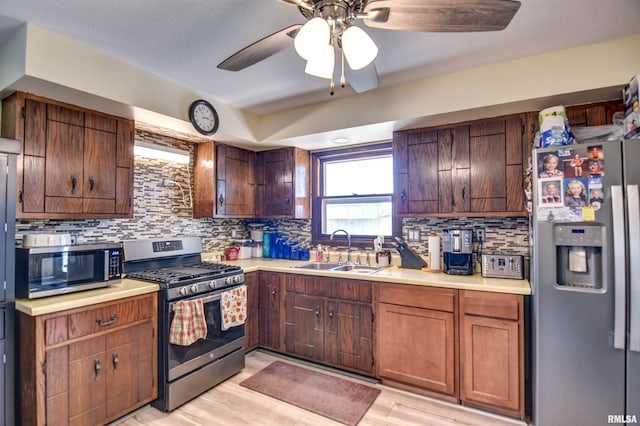 909 E Heights Ave, Taylorville, IL 62568 - kitchen featuring stainless steel appliances, light countertops, tasteful backsplash, a ceiling fan, and light wood-style flooring