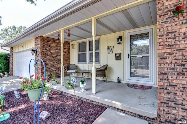 909 E Heights Ave, Taylorville, IL 62568 - view of exterior entry with a porch, a garage, brick siding, and concrete driveway