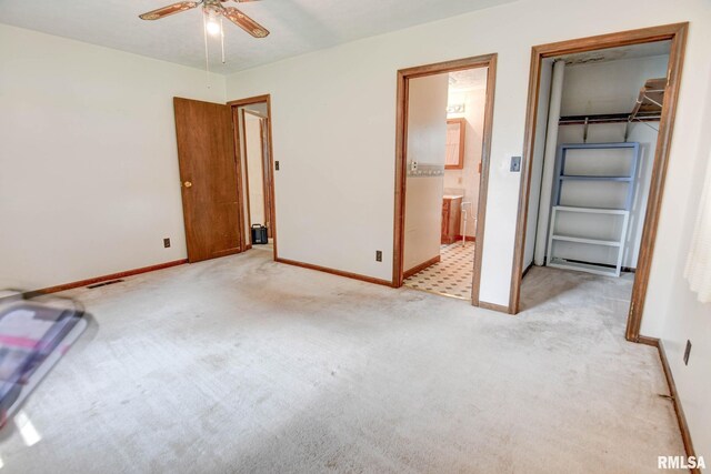 128 Macarthur Blvd, Pana, IL 62557 - unfurnished bedroom featuring light colored carpet, baseboards, a walk in closet, connected bathroom, and a ceiling fan