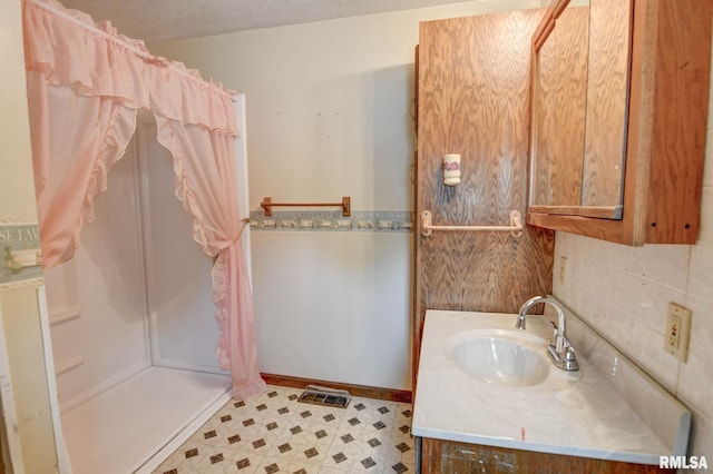 128 Macarthur Blvd, Pana, IL 62557 - bathroom featuring a shower with shower curtain, vanity, tile patterned floors, tasteful backsplash, and a textured ceiling