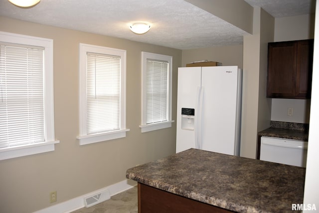 2531 Yale Blvd, Springfield, IL 62703 - kitchen featuring white refrigerator with ice dispenser, dark countertops, dark brown cabinets, baseboards, and a textured ceiling