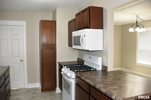 2531 Yale Blvd, Springfield, IL 62703 - kitchen with white appliances, dark countertops, a chandelier, and pendant lighting