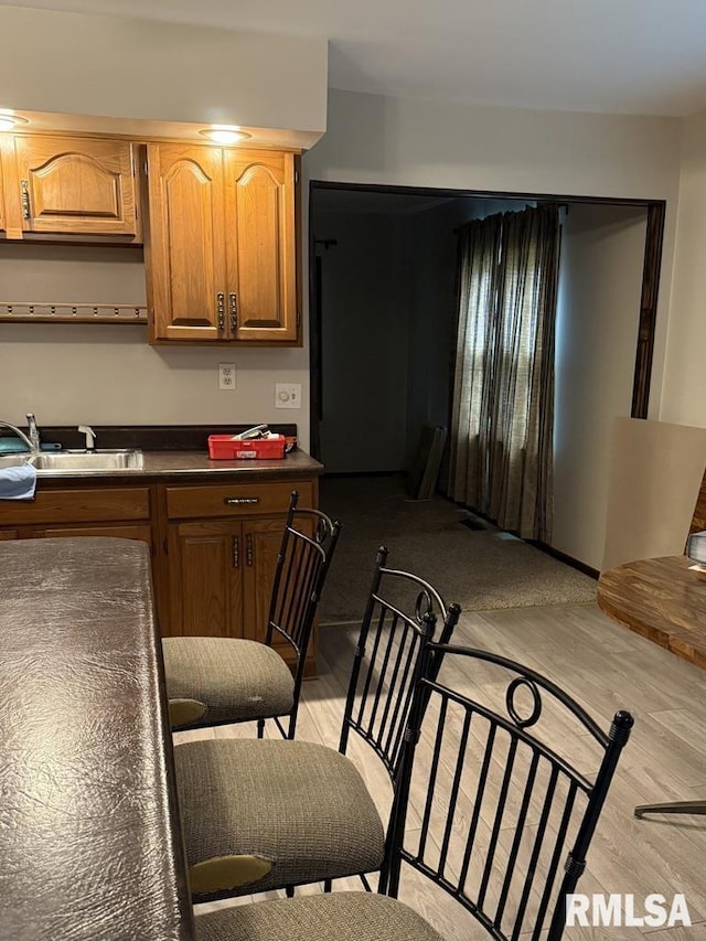 504 W Chestnut St, Chatham, IL 62629 - kitchen with light wood-style flooring, dark countertops, and a sink