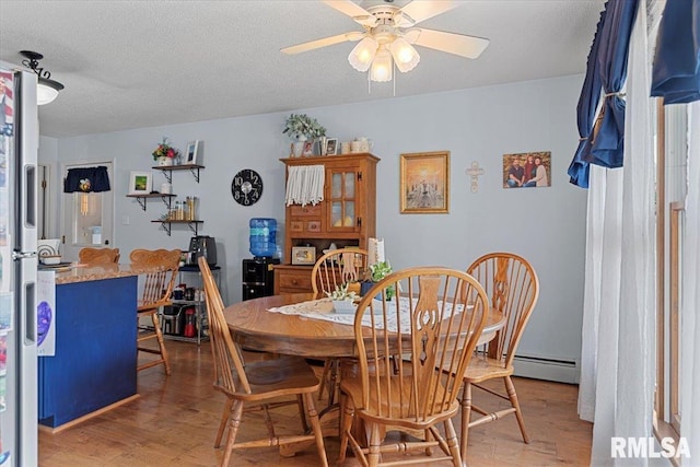 122 W Chapin St, Litchfield, IL 62056 - dining room featuring light wood-style floors, a baseboard radiator, a ceiling fan, and a textured ceiling