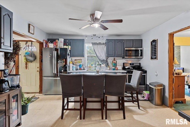 417 W Franklin St, Girard, IL 62640 - kitchen featuring stainless steel appliances, a ceiling fan, backsplash, light countertops, and a sink