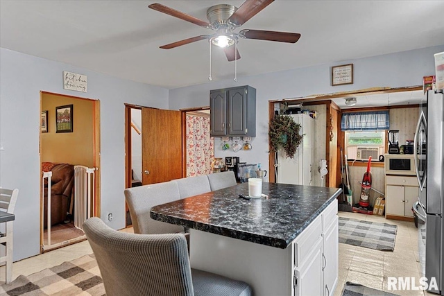 417 W Franklin St, Girard, IL 62640 - kitchen featuring freestanding refrigerator, a ceiling fan, dark countertops, a center island, and cooling unit