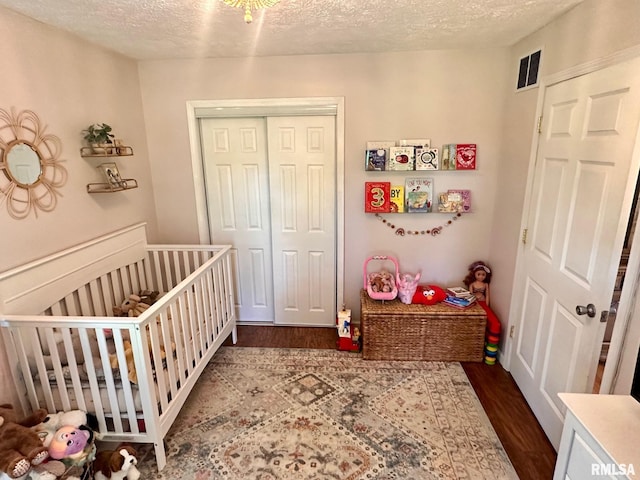 2900 Old State Rd, Alexander, IL 62601 - bedroom with wood finished floors, a closet, a crib, and a textured ceiling