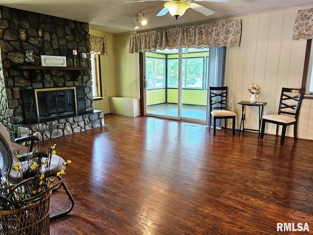 12862 Winnebago Dr, Plainview, IL 62685 - living room with wood finished floors, ceiling fan, a textured ceiling, a fireplace, and track lighting