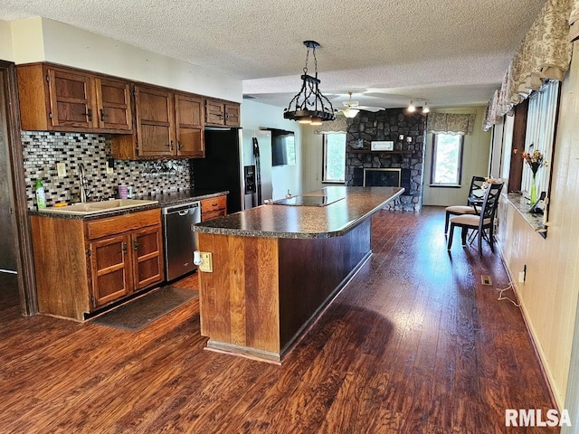 12862 Winnebago Dr, Plainview, IL 62685 - kitchen featuring stainless steel appliances, a sink, dark countertops, a textured ceiling, and dark wood-type flooring