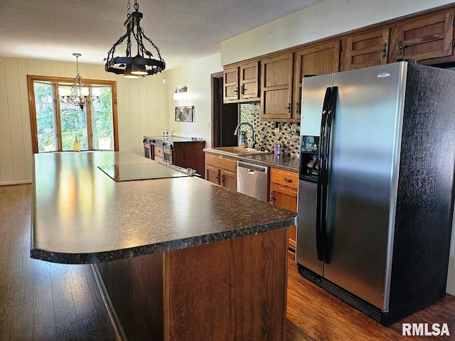 12862 Winnebago Dr, Plainview, IL 62685 - kitchen with stainless steel appliances, a chandelier, dark countertops, dark wood-style flooring, and a sink
