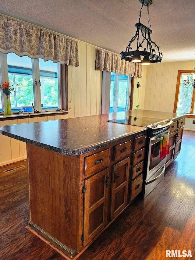 12862 Winnebago Dr, Plainview, IL 62685 - kitchen with electric range, a textured ceiling, dark wood-style flooring, dark countertops, and a center island