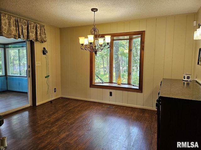 12862 Winnebago Dr, Plainview, IL 62685 - unfurnished dining area featuring dark wood finished floors, a chandelier, a textured ceiling, plenty of natural light, and baseboards