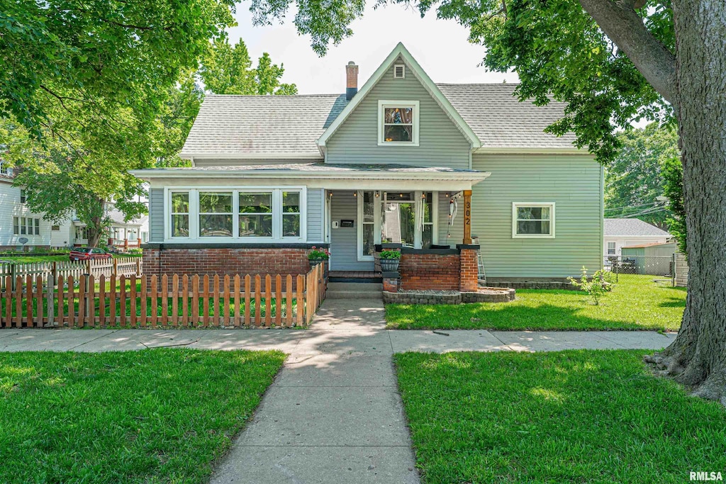 302 S Center St, Clinton, IL 61727 - view of front of home with a porch, roof with shingles, and a chimney