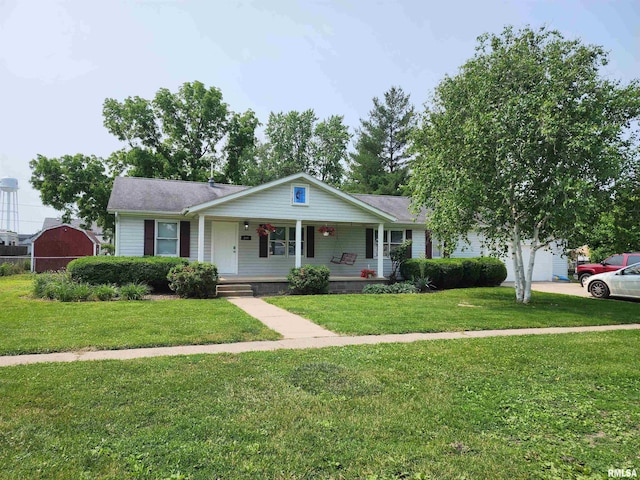 208 Elm St, Dawson, IL 62520 - view of front of house with covered porch, a front yard, a garage, driveway, and an outbuilding