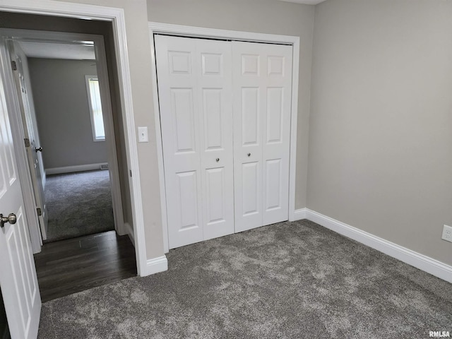 208 Elm St, Dawson, IL 62520 - unfurnished bedroom featuring dark carpet, a closet, and baseboards