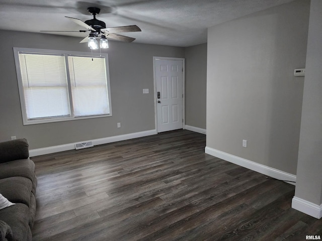 208 Elm St, Dawson, IL 62520 - unfurnished living room featuring a ceiling fan, baseboards, and dark wood-style flooring
