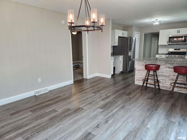 208 Elm St, Dawson, IL 62520 - kitchen with stainless steel appliances, a chandelier, a breakfast bar, and white cabinets