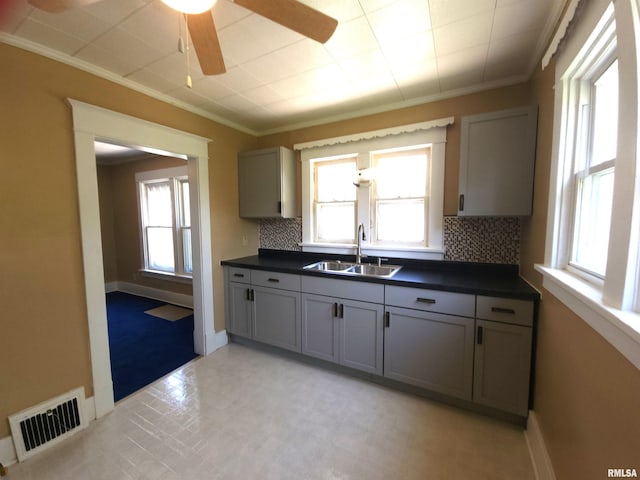 2240 Holmes Ave, Springfield, IL 62704 - kitchen featuring dark countertops, backsplash, crown molding, ceiling fan, and gray cabinets