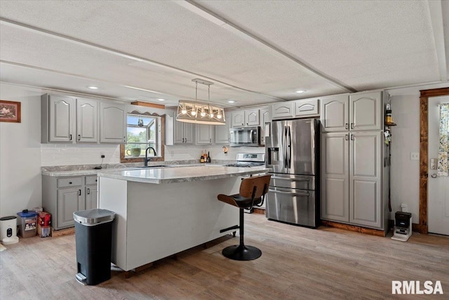 14455 E Dutch Henry Rd, Lewistown, IL 61542 - kitchen with stainless steel appliances, recessed lighting, gray cabinets, light wood-style floors, and a kitchen island
