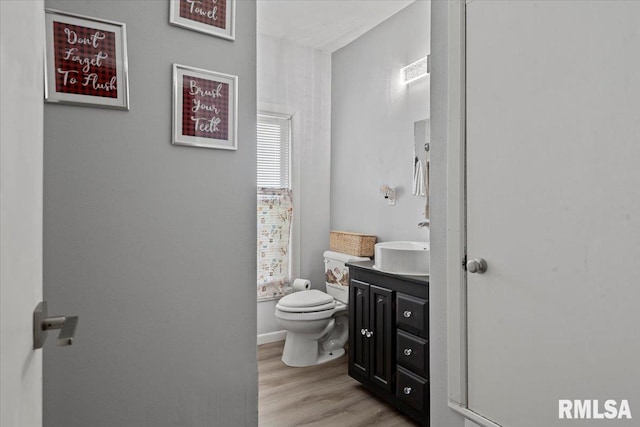 14455 E Dutch Henry Rd, Lewistown, IL 61542 - bathroom featuring toilet, vanity, and wood finished floors