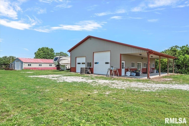 14455 E Dutch Henry Rd, Lewistown, IL 61542 - back of property featuring an outdoor structure, a garage, and a yard