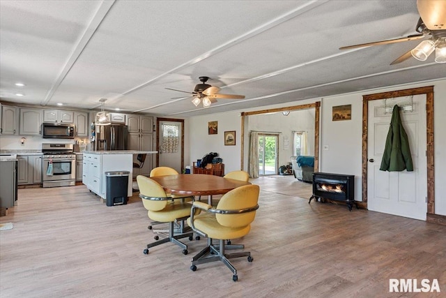 14455 E Dutch Henry Rd, Lewistown, IL 61542 - dining room featuring a ceiling fan, a wood stove, light wood finished floors, a textured ceiling, and recessed lighting