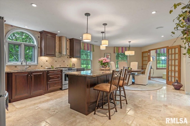 9 Windfall Ln, Cantrall, IL 62625 - kitchen with gas stove, dark stone countertops, backsplash, a center island, and plenty of natural light