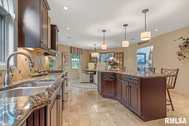 9 Windfall Ln, Cantrall, IL 62625 - kitchen with a kitchen breakfast bar, tasteful backsplash, range, decorative light fixtures, and dark stone countertops