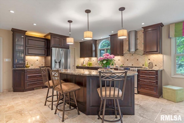 9 Windfall Ln, Cantrall, IL 62625 - kitchen featuring appliances with stainless steel finishes, wall chimney range hood, a breakfast bar area, a center island, and recessed lighting