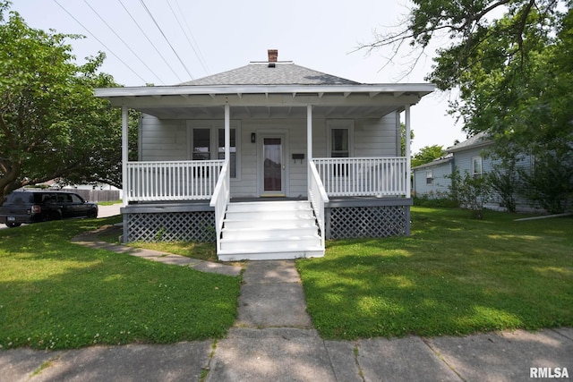 931 W Vandeveer St, Taylorville, IL 62568 - bungalow with a porch, a front lawn, roof with shingles, and a chimney