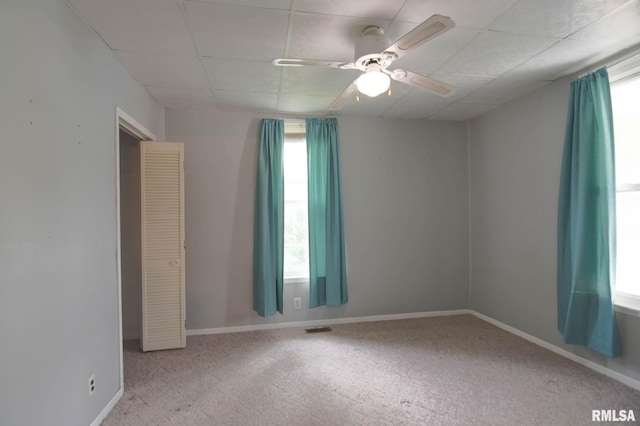931 W Vandeveer St, Taylorville, IL 62568 - empty room with a paneled ceiling, healthy amount of natural light, carpet flooring, and a ceiling fan