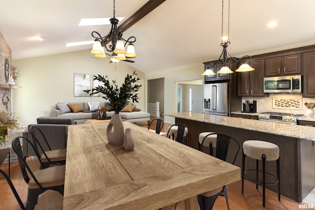6718 Shadow Ln, Quincy, IL 62305 - dining area featuring lofted ceiling, a skylight, light wood-style flooring, and a chandelier