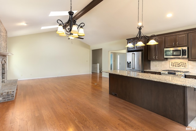 6718 Shadow Ln, Quincy, IL 62305 - kitchen featuring stainless steel appliances, dark brown cabinets, open floor plan, and tasteful backsplash