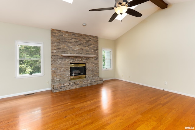 6718 Shadow Ln, Quincy, IL 62305 - unfurnished living room with healthy amount of natural light, beamed ceiling, ceiling fan, wood finished floors, and high vaulted ceiling