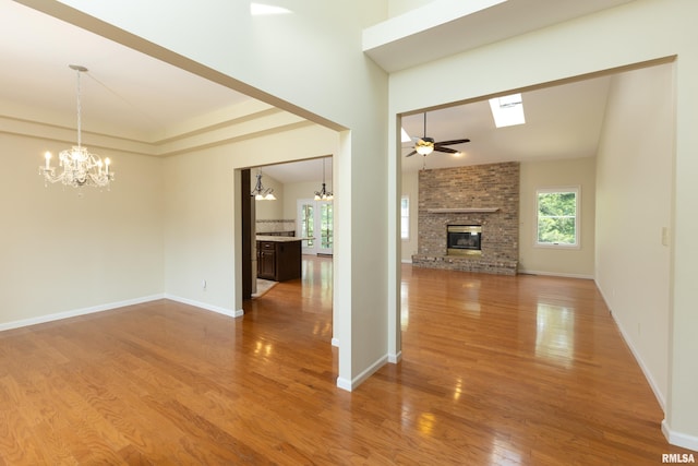 6718 Shadow Ln, Quincy, IL 62305 - unfurnished living room with a chandelier, a fireplace, wood finished floors, and ceiling fan