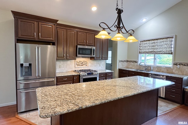 6718 Shadow Ln, Quincy, IL 62305 - kitchen with appliances with stainless steel finishes, lofted ceiling, dark brown cabinets, light wood-style flooring, and tasteful backsplash