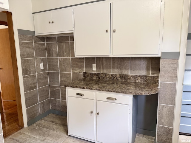 465 Fifer St, Galesburg, IL 61401 - kitchen with white cabinetry, backsplash, light wood-type flooring, and dark stone countertops